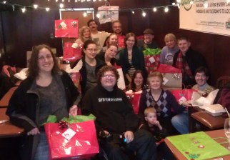 Photo of ~15 volunteers with wrapped gifts.