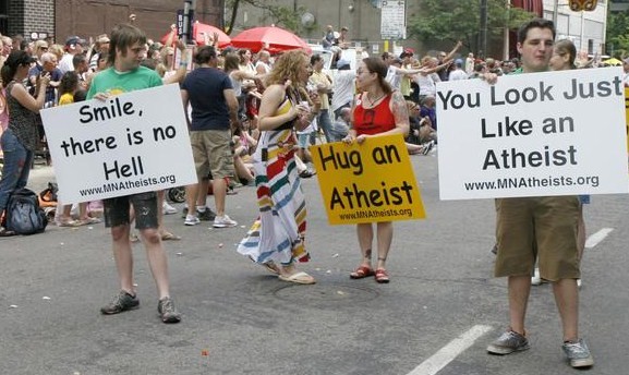 Photo of attendee approaching MNA member with a "Hug an Atheist" sign.